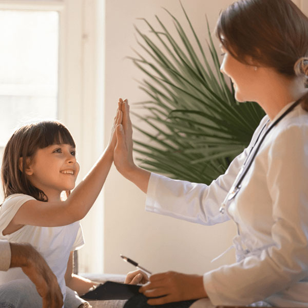 female doctor giving hi-five to young girl